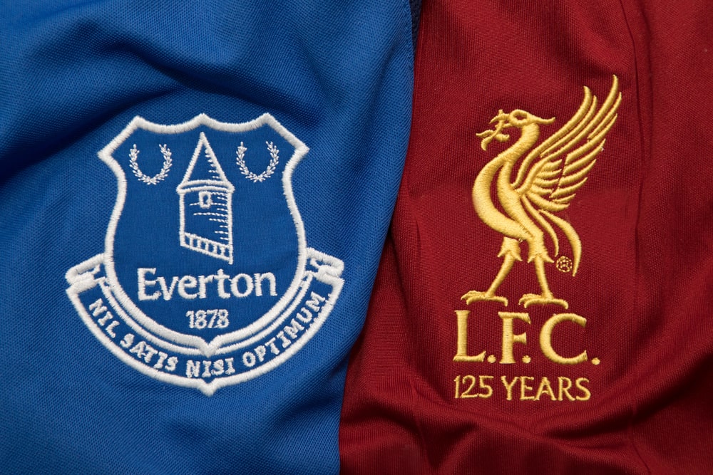 Liverpool and Everton logos on jerseys