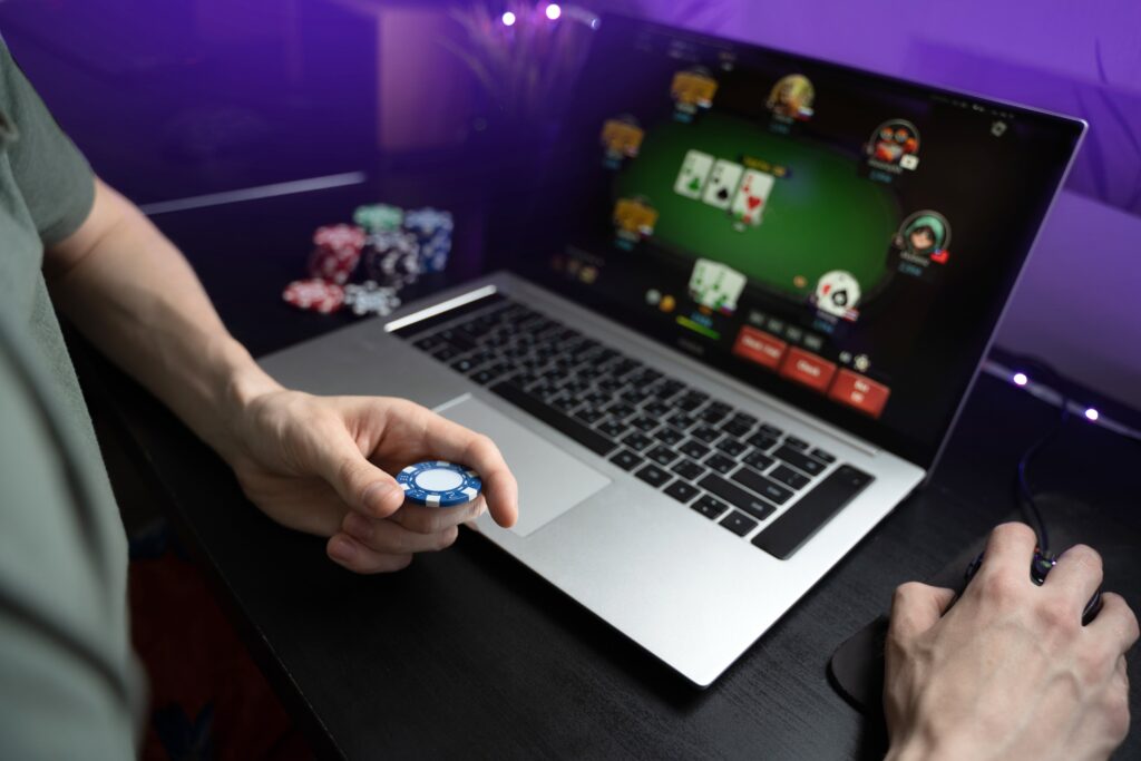 man playing online poker on laptop